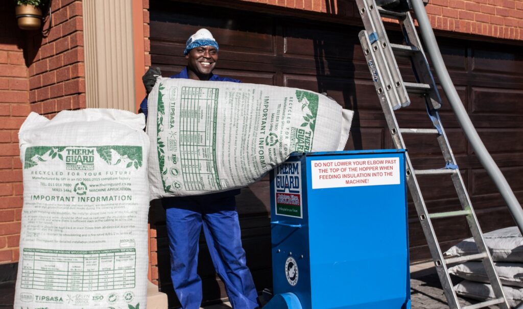 Thermguard installer loading a bag of cellulose fibre insulation into the blowing machine